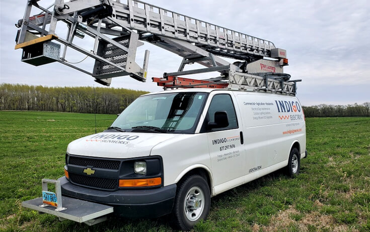 Indigo Signs Electric Ladder Van Parked in Field