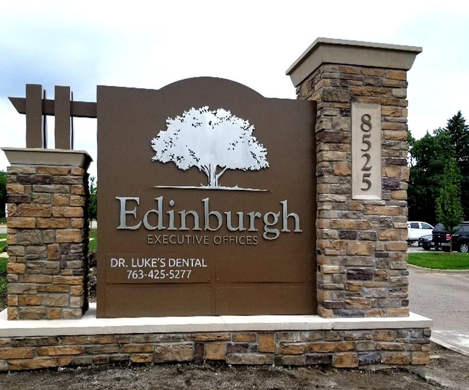 Custom Shaped Monument sign with routed logo and brick base for Edinburgh Executive offices