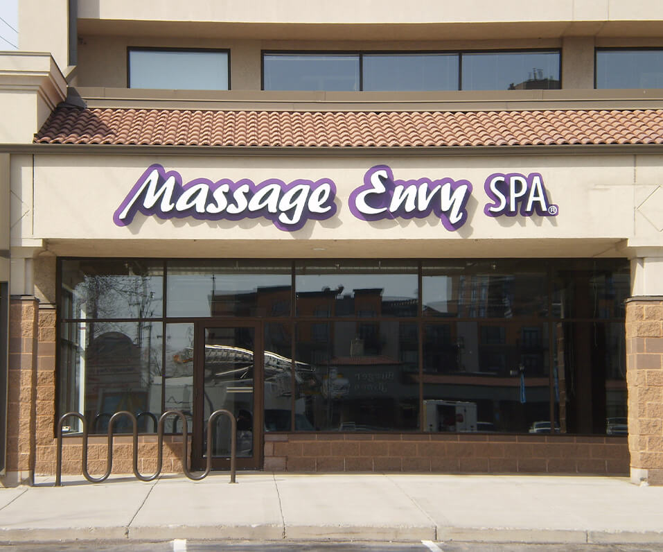 Massage Envy Spa Channel letters on building front with custom shaped purple backer panel