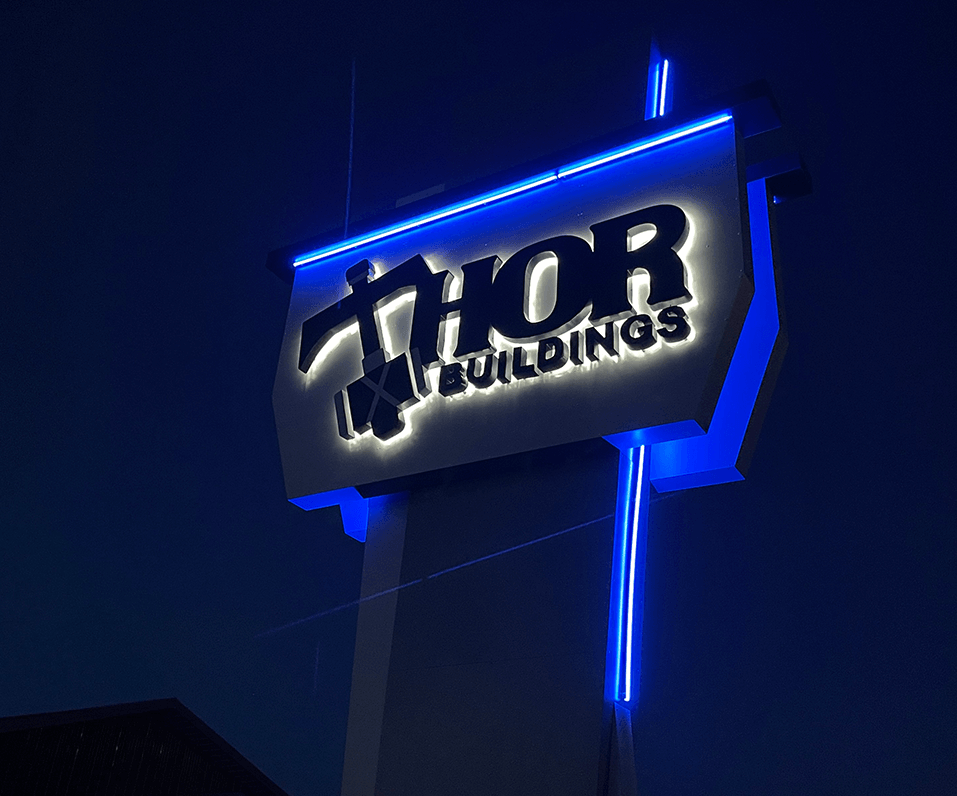 Thor Building Pylon Sign Custom Shaped Cabinet Halo Illuminated Letters and Blue Accent Lighting Fargo ND Night Photo